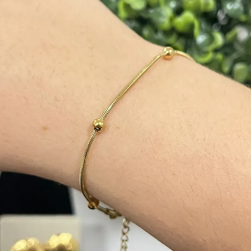 Pulseira com esferas no aço dourado